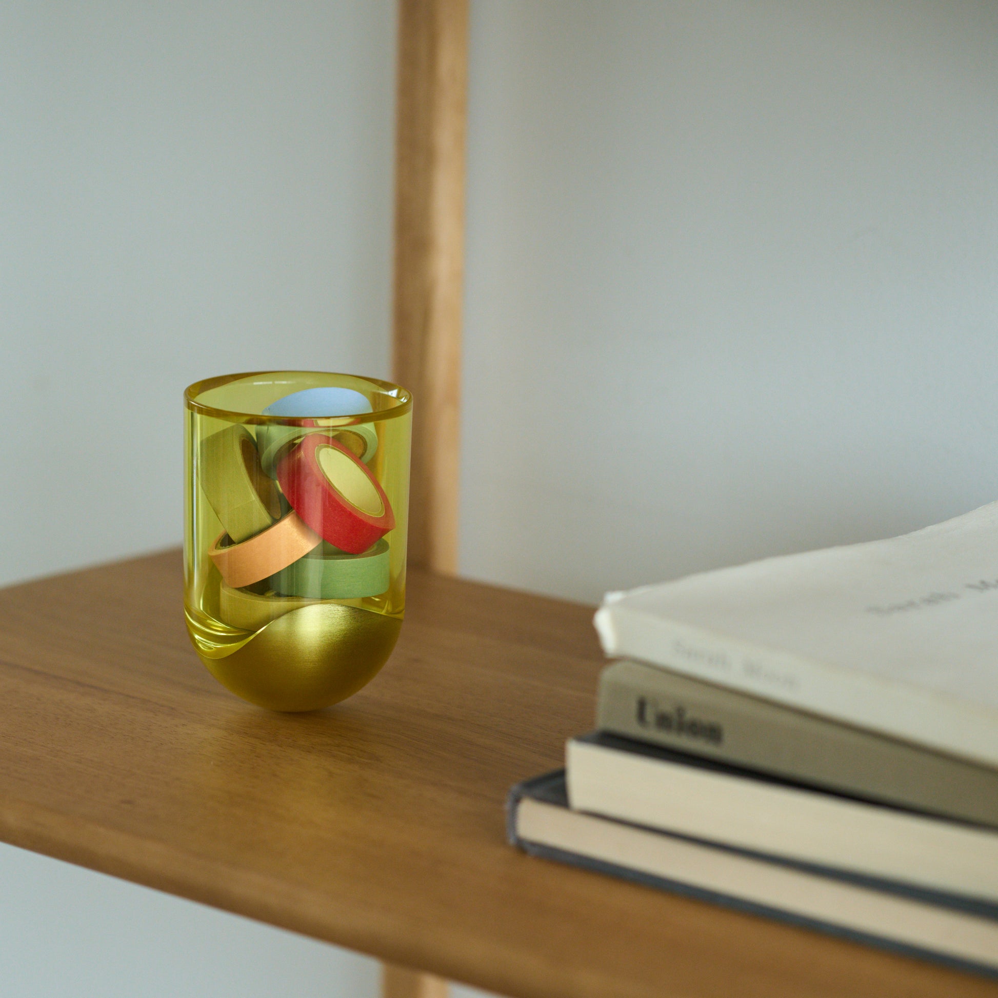 透明で黄色いSESEKIにテープを入れているシーン画像/SESEIを小物入れとして使用している/SESEKI /SE-SG-C-15(色:シルバー/グロス/黄)